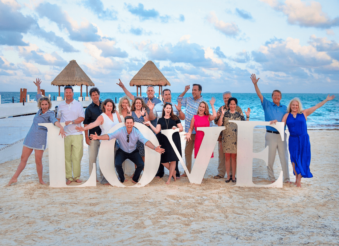 About Our Agency - Portrait of Cheerful Producers on the Southern States Insurance Team Having Fun Posing Next to a Love Sign on a Beach During a Reward Trip to Mexico